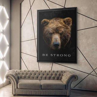 Modernes Wohnzimmer mit Leinwandbild Bärenkopf und Motivationsspruch Be Strong an der Wand.