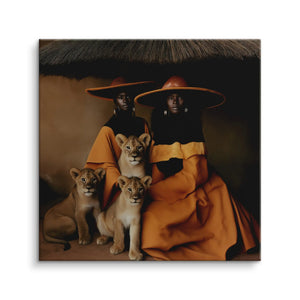 Sisters of the Sun Wandbild auf Leinwand: zwei Frauen in ockerfarbenen Gewändern und breiten Hüten sitzen mit drei Löwenbabys vor erdigem Hintergrund