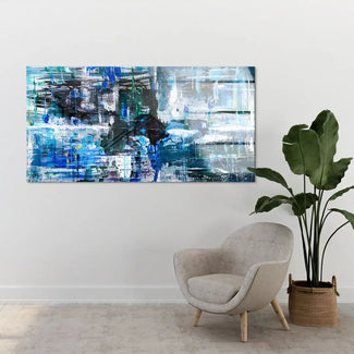 Modernes abstraktes Wandbild in Blau- und Grüntönen über Sessel und Zimmerpflanze