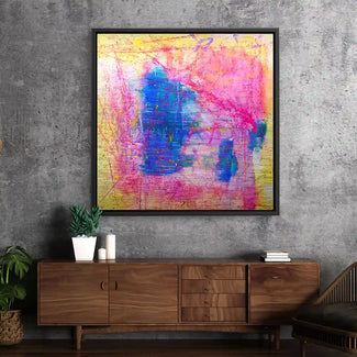 Abstraktes Wandbild mit kräftigen Farben in Blau, Pink und Gelb an grauer Wohnzimmerwand