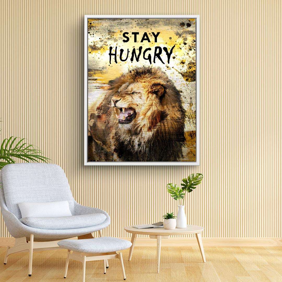 Leinwandbild mit brüllendem Löwen und Motivationsspruch Stay Hungry im modernen Wohnzimmer