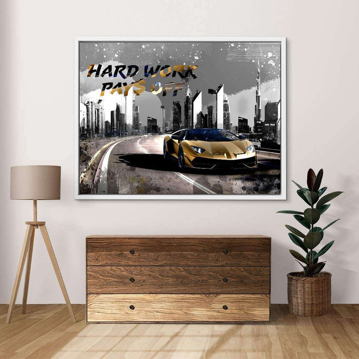 Motivierendes Wandbild mit goldenem Sportwagen, Skyline und Schriftzug 'Hard Work Pays Off'.