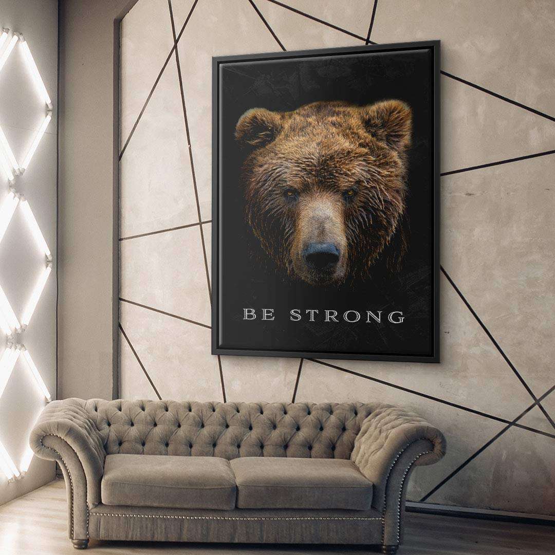 Modernes Wohnzimmer mit Leinwandbild Bärenkopf und Motivationsspruch Be Strong an der Wand.