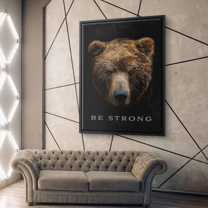 Modernes Wohnzimmer mit Leinwandbild Bärenkopf und Motivationsspruch Be Strong an der Wand.