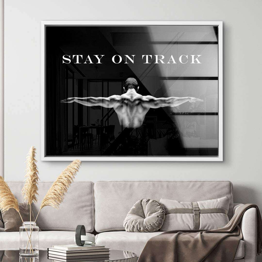 Schwarzweiß Wandbild mit muskulösem Rücken und Motivationsspruch Stay on Track im Wohnzimmer