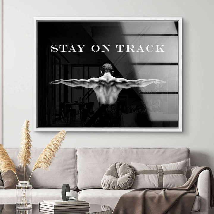 Schwarzweiß Wandbild mit muskulösem Rücken und Motivationsspruch Stay on Track im Wohnzimmer