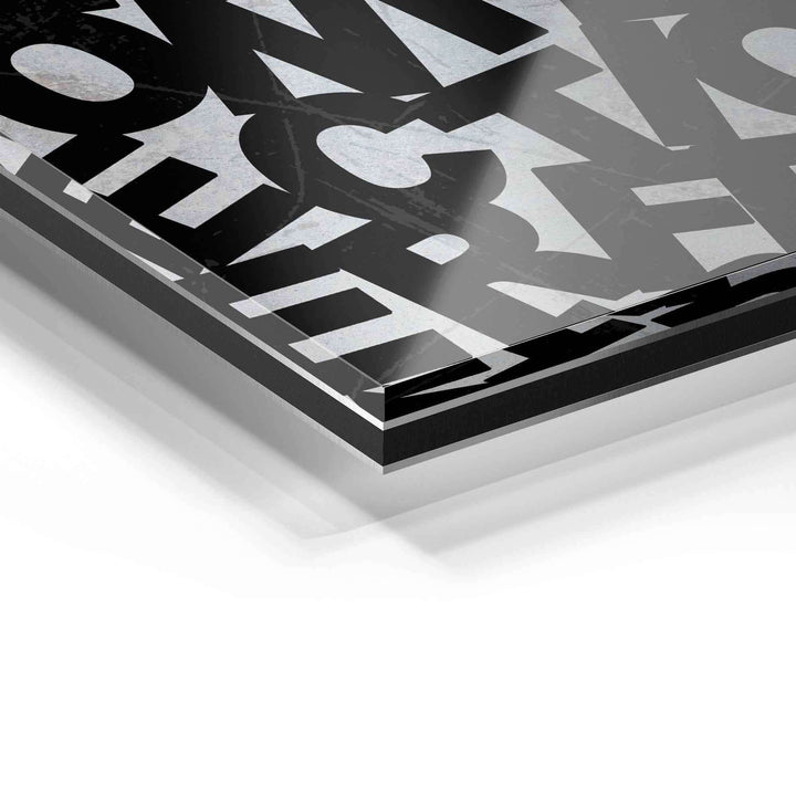 Detailaufnahme eines modernen Wandbilds aus Acrylglas mit abstraktem, schwarz-weißem Buchstabenmotiv