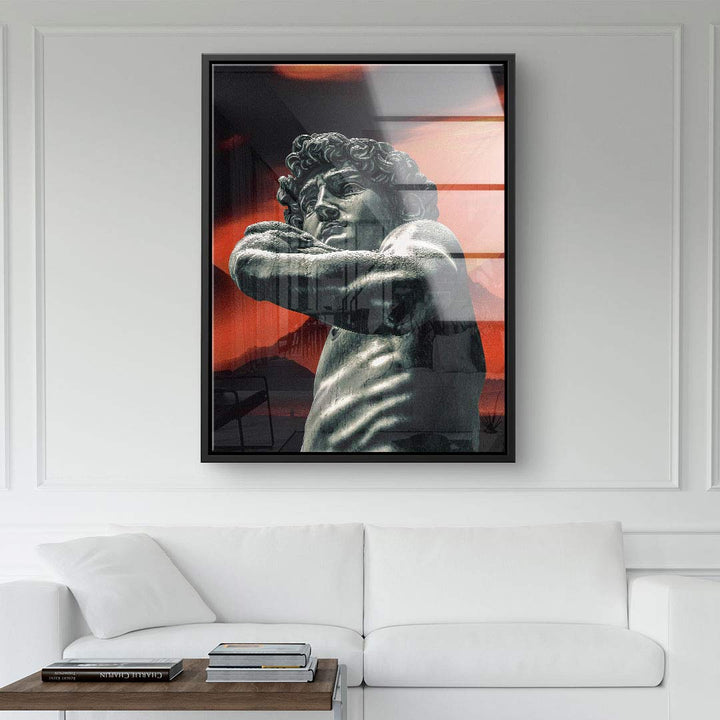 Modernes Wandbild mit Statue vor abstraktem, rot-schwarzem Hintergrund über weißem Sofa