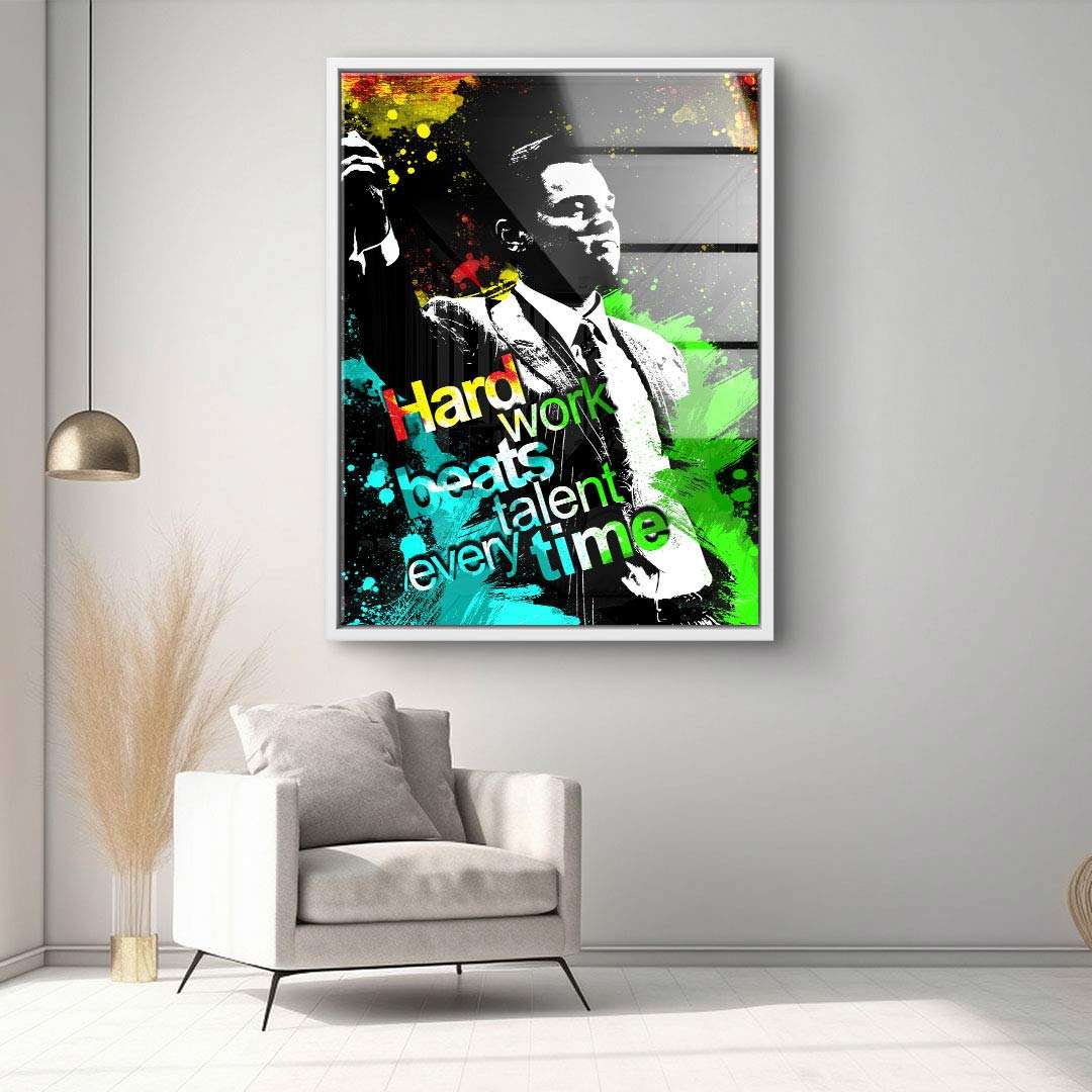 Motivationsbild im modernen Wohnzimmer, Leinwand mit Zitat 'Hard work beats talent every time', Pop Art Stil mit bunter Farbexplosion und Mann im Anzug.