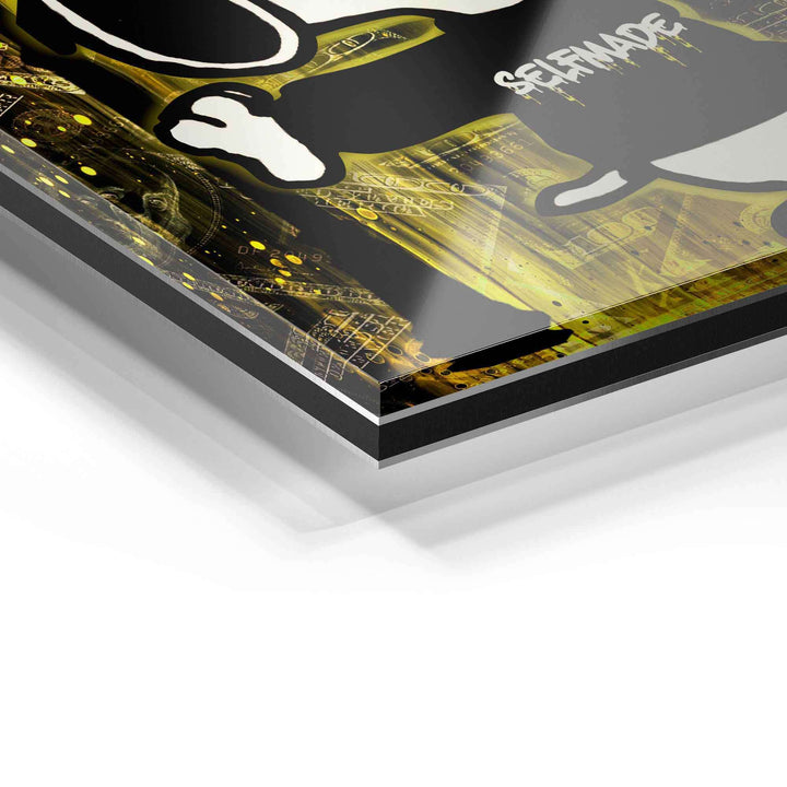 Detailaufnahme eines modernen Wandbilds auf Acrylglas mit gelbem, digitalem Pop Art Motiv und "Selfmade" Schriftzug.