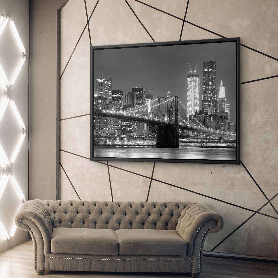 Modernes Wohnzimmer mit grau-beigem Sofa und Wandbild einer beleuchteten Skyline bei Nacht.