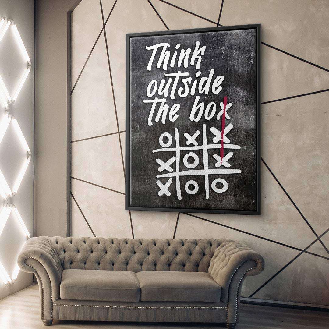 Modernes Wandbild mit Spruch 'Think outside the box' und Tic-Tac-Toe Motiv über einem Sofa