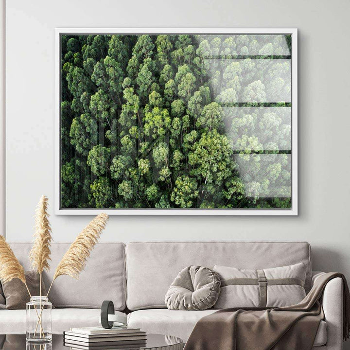 Modernes Wandbild mit Drohnenaufnahme eines grünen Waldes über beigem Sofa im Wohnzimmer