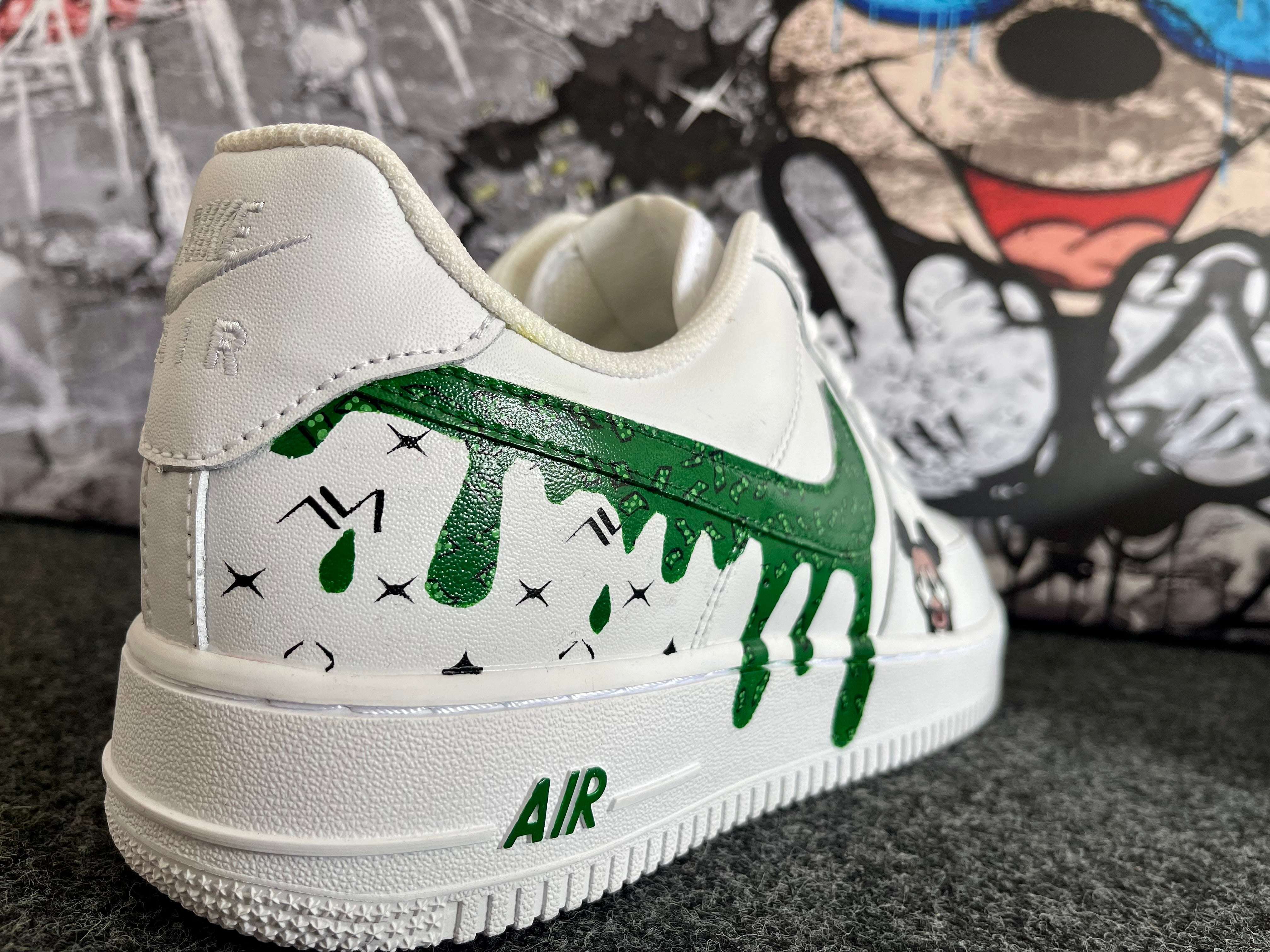 Weißer Sneaker mit grünem, verlaufendem Graffiti-Design und Pop Art-Illustration im Hintergrund