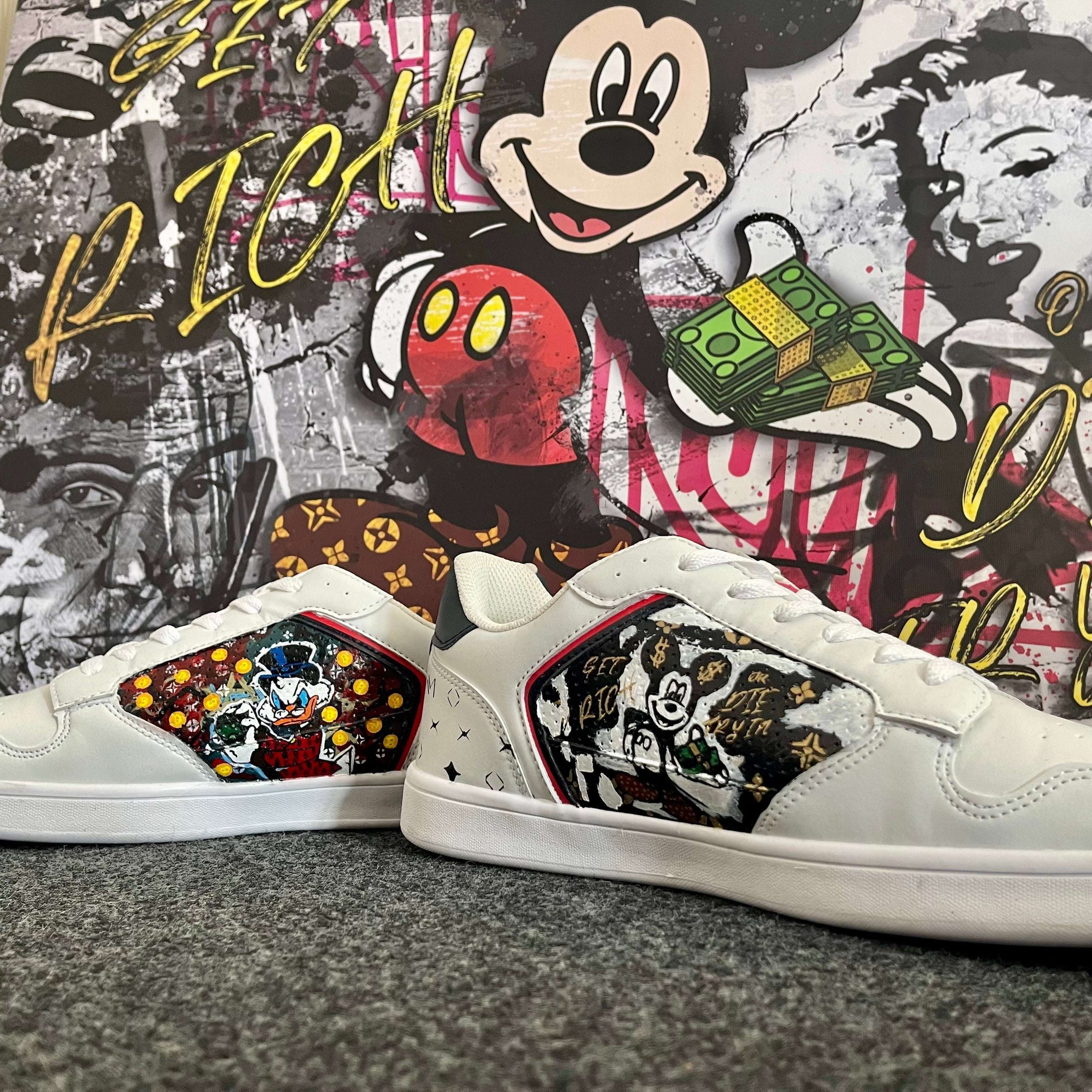 Weiße Sneaker mit Pop Art Comic-Motiven vor buntem Streetart-Wandbild