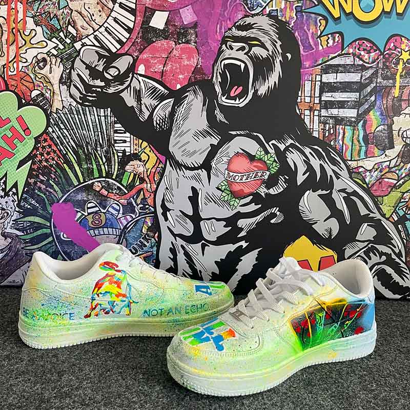 Bunte Sneaker vor Pop Art Wandbild mit Gorilla und Graffiti-Elementen, kreatives Design