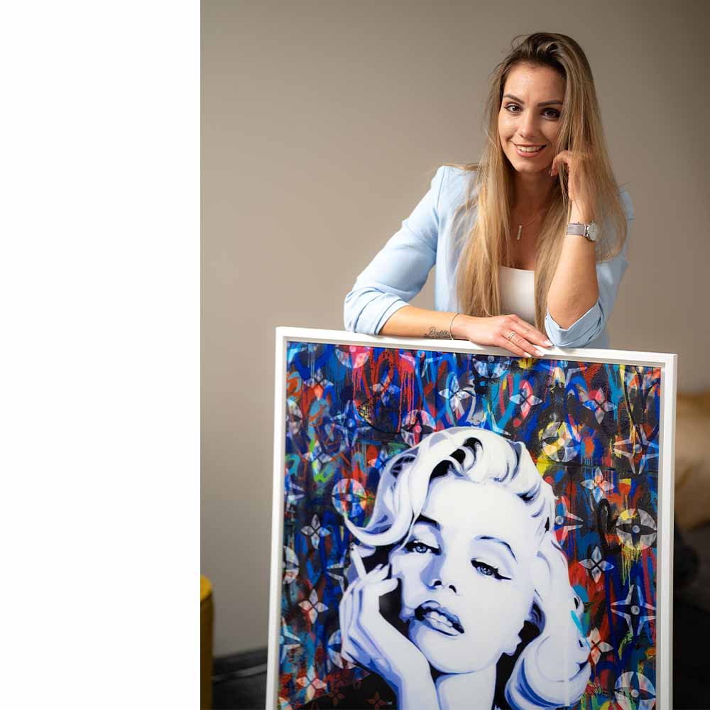 Frau mit modernem Pop Art Wandbild, Porträt einer blonden Frau vor buntem Hintergrund