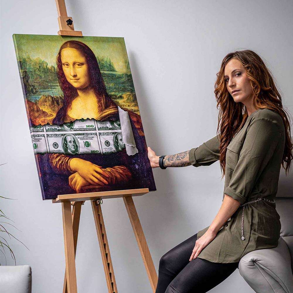 Frau sitzt neben modernem Mona Lisa Leinwandbild mit integriertem Geldschein-Motiv auf Staffelei