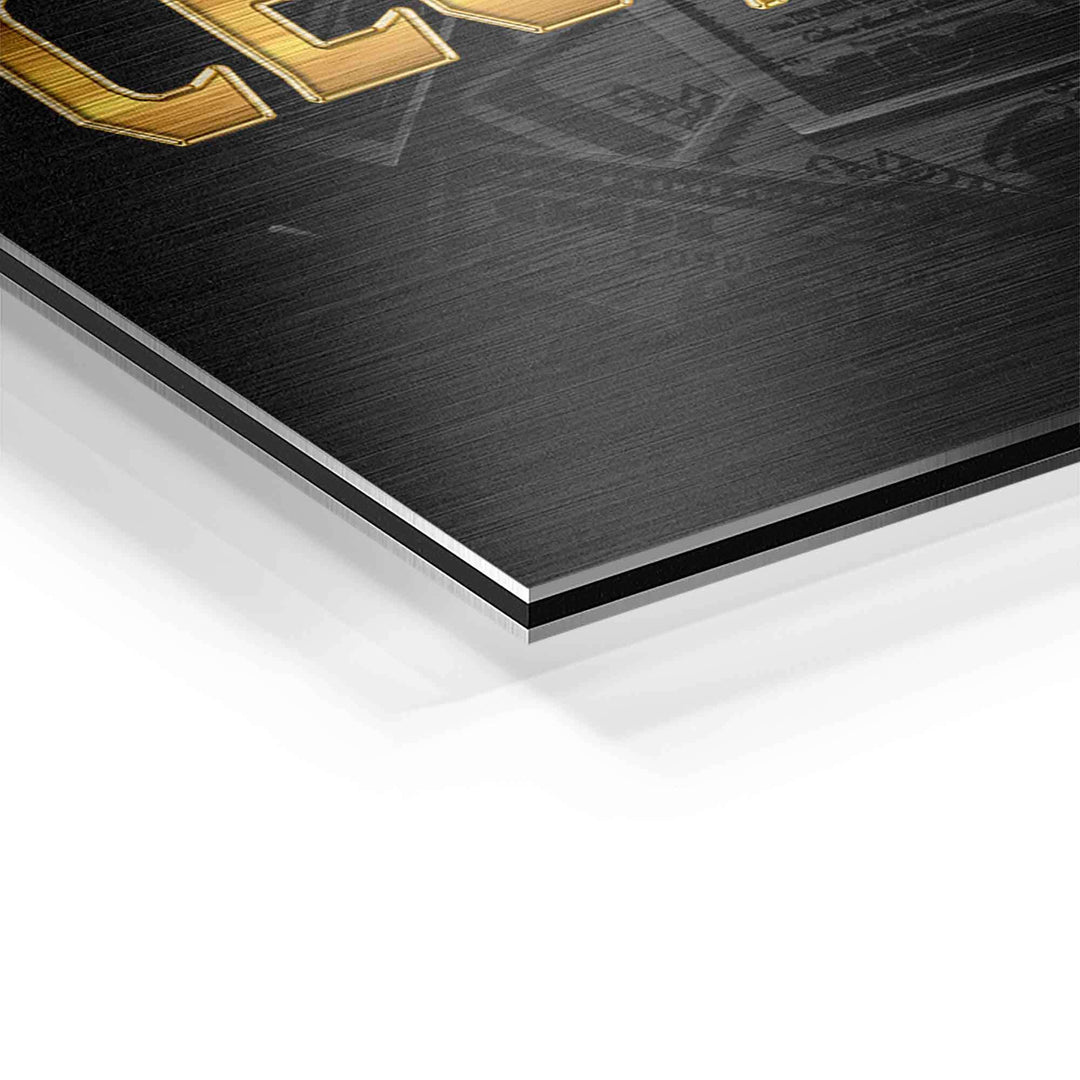 Detailansicht eines Motivationsbilds auf Aluminium mit goldener Schrift und Geldscheinen im Hintergrund