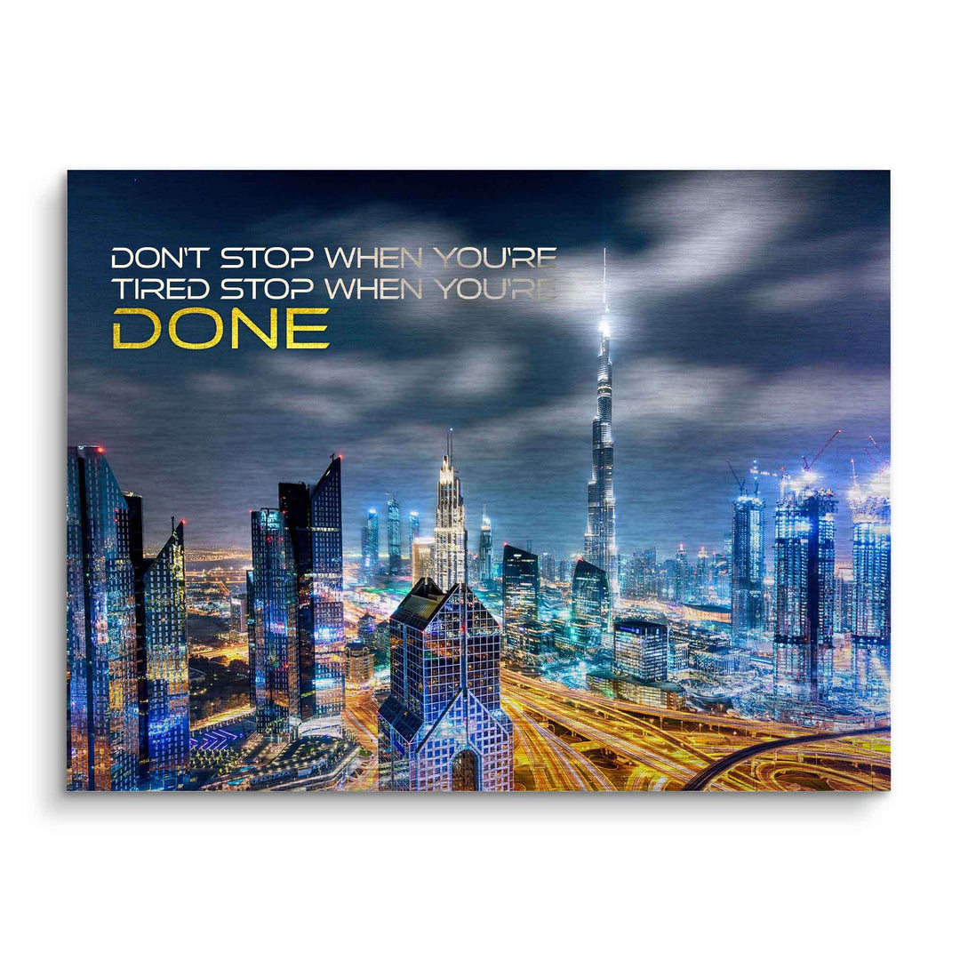 Motivationsbild mit Dubai Skyline bei Nacht, Burj Khalifa, leuchtende Stadtlichter, inspirierendes Zitat