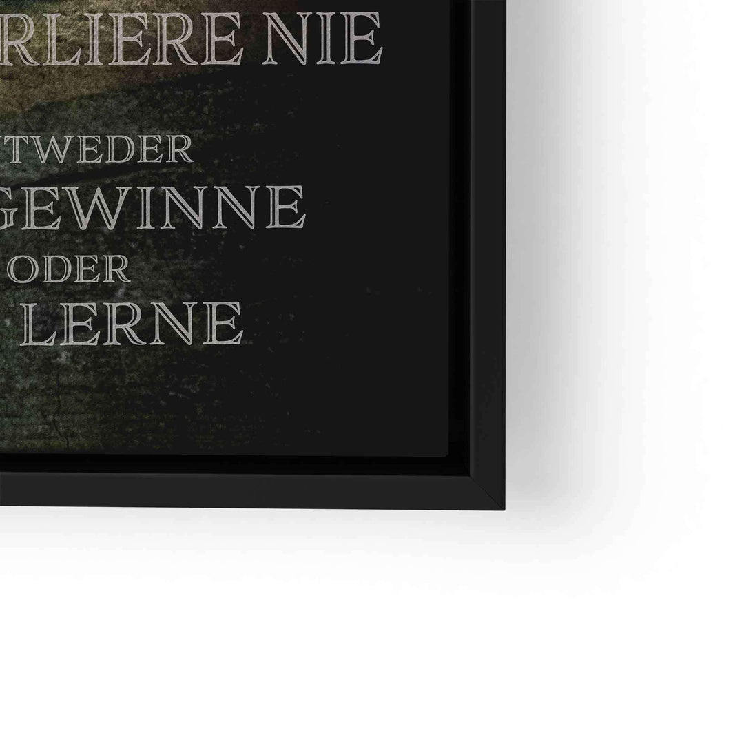 Motivationsbild mit grünem Löwen und Spruch in Schwarz-Weiß in schwarzem Rahmen