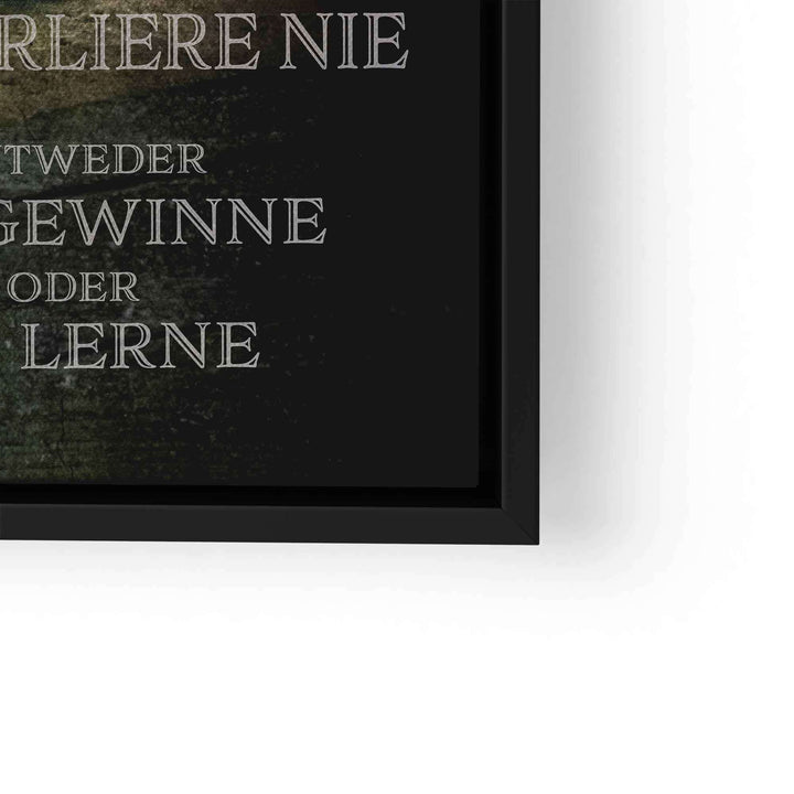 Motivationsbild mit grünem Löwen und Spruch in Schwarz-Weiß in schwarzem Rahmen