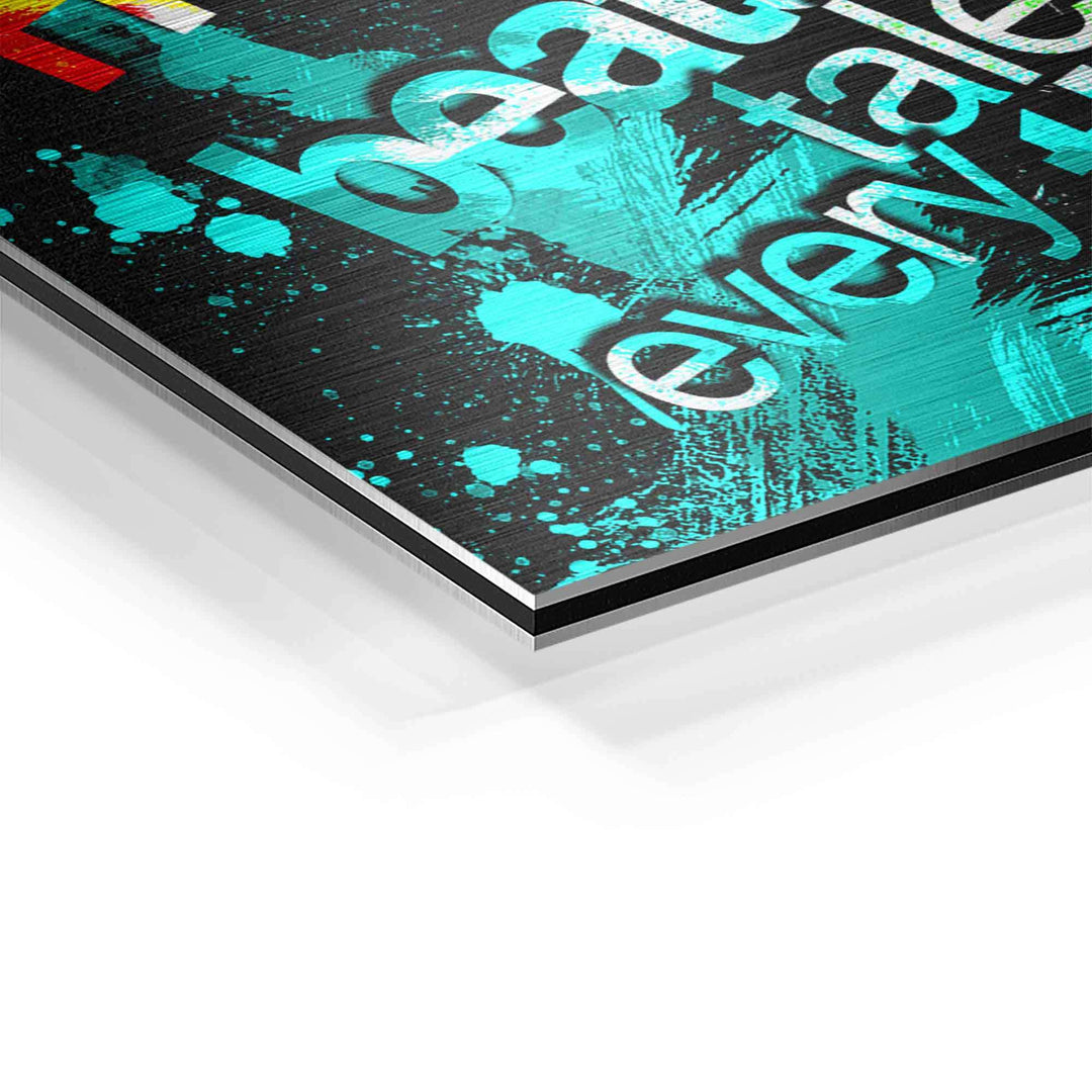 Detail eines modernen Motivationsbildes auf Aluminium mit türkisen Farbspritzern und Text.