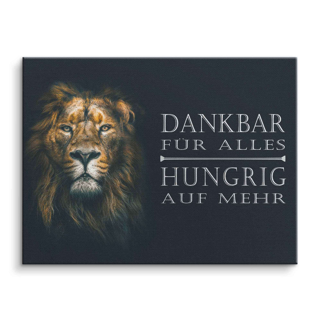 Motivationsbild mit Löwenkopf und Spruch 'Dankbar für alles, hungrig auf mehr' auf Leinwand