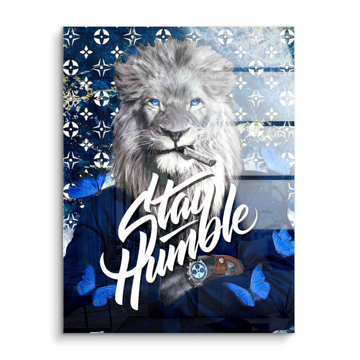 Motivationsbild Löwe im Anzug mit Zigarre, blauen Schmetterlingen und Schriftzug Stay Humble