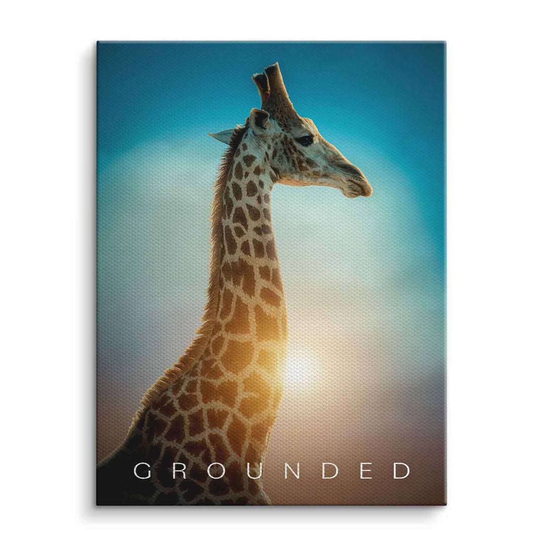 Leinwandbild mit Giraffe vor blauem Himmel und Sonnenlicht, Motivationsbild mit Text 'Grounded'