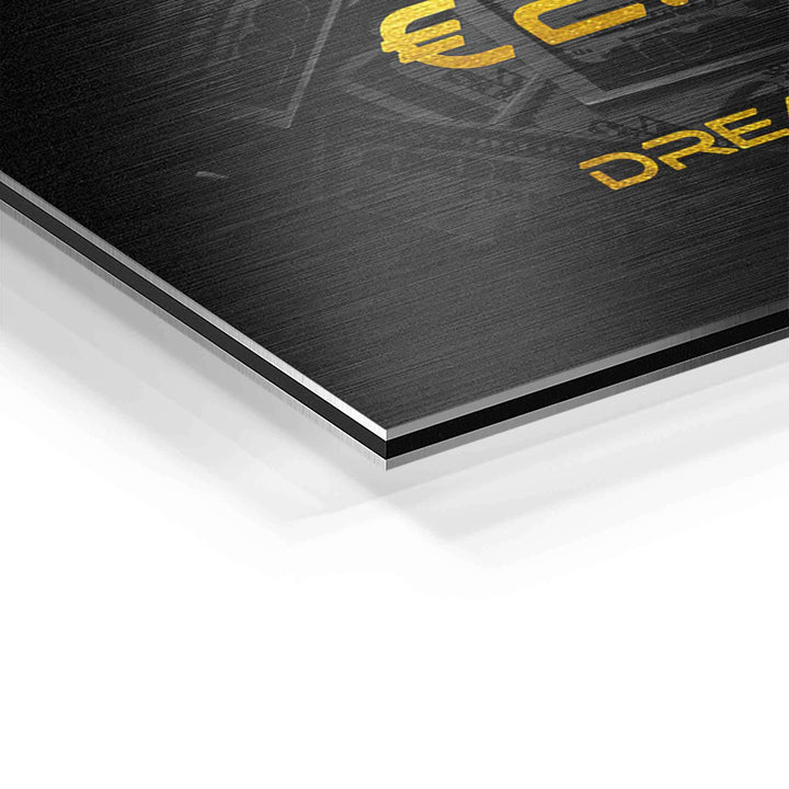 Detailaufnahme eines Motivationsbilds auf gebürstetem Aluminium mit goldfarbener Schrift.