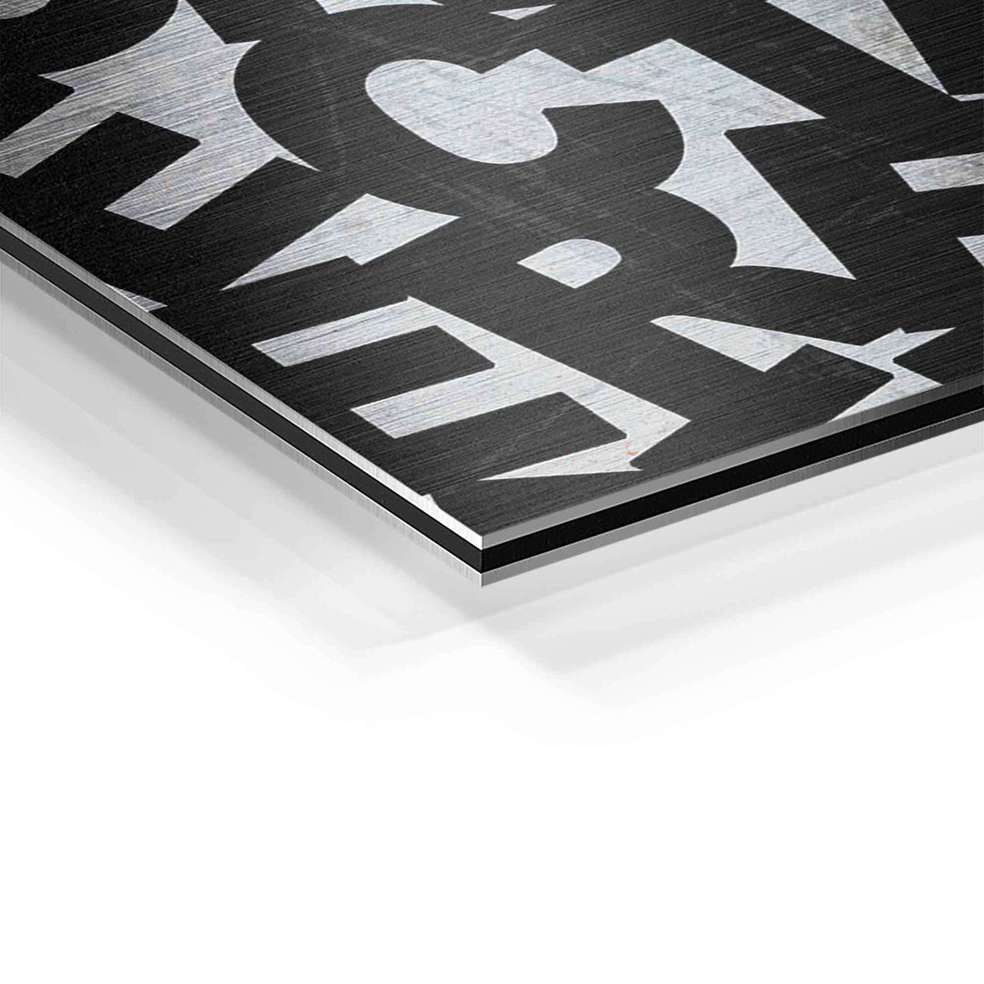 Detailaufnahme eines Motivationsbilds auf Aluminium mit schwarzem Schriftzug und gebürsteter Oberfläche
