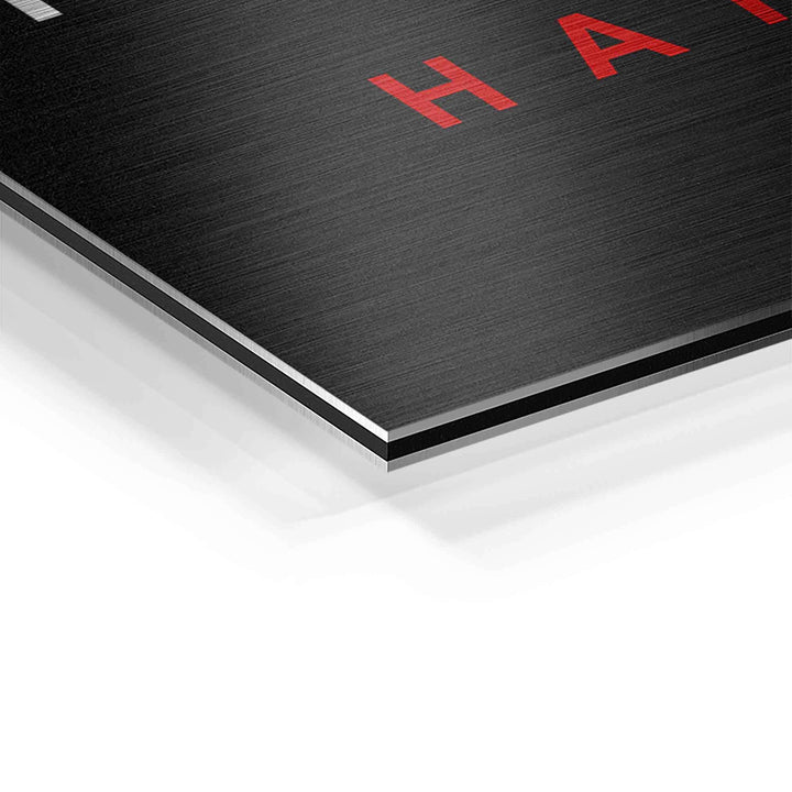 Detailaufnahme eines Motivationsbilds auf gebürstetem Aluminium mit rotem Schriftzug H.