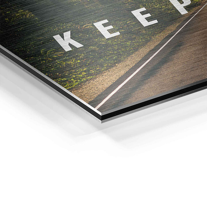 Detailaufnahme Motivationsbild mit Waldstraße und Text auf gebürstetem Aluminium