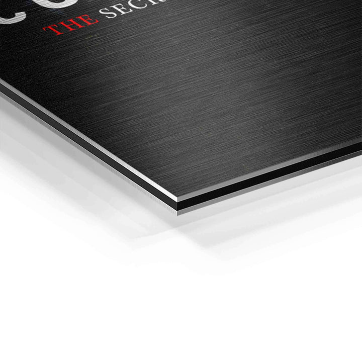 Detailaufnahme gebürstete Aluminiumplatte mit Motivationsschrift auf schwarzer Oberfläche