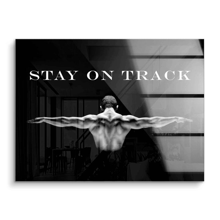 Motivationsbild mit muskulösem Mann im Gym, ausgebreitete Arme, Schriftzug 'Stay on Track'.