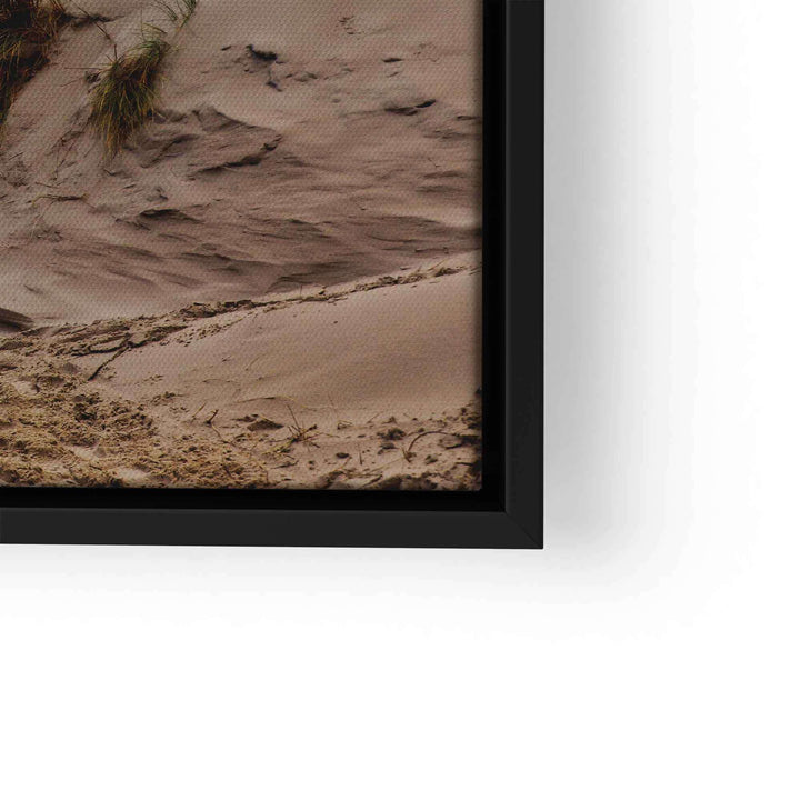 Wandbild mit Sanddünen und Gräsern am Meer in schwarzem Rahmen