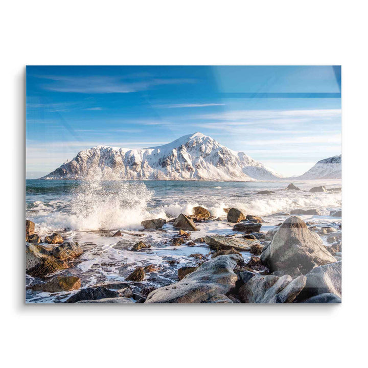 Wandbild mit schneebedeckten Bergen, rauer Küste und Meereswellen unter blauem Himmel