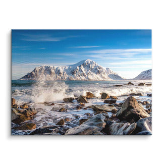 Wandbild mit verschneitem Berg, stürmischer Meeresküste und Felsen unter blauem Himmel