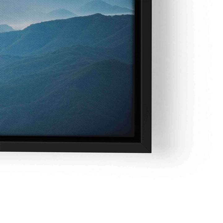 Wandbild mit blauen Bergen, Himmel und Wolken im schwarzen Rahmen