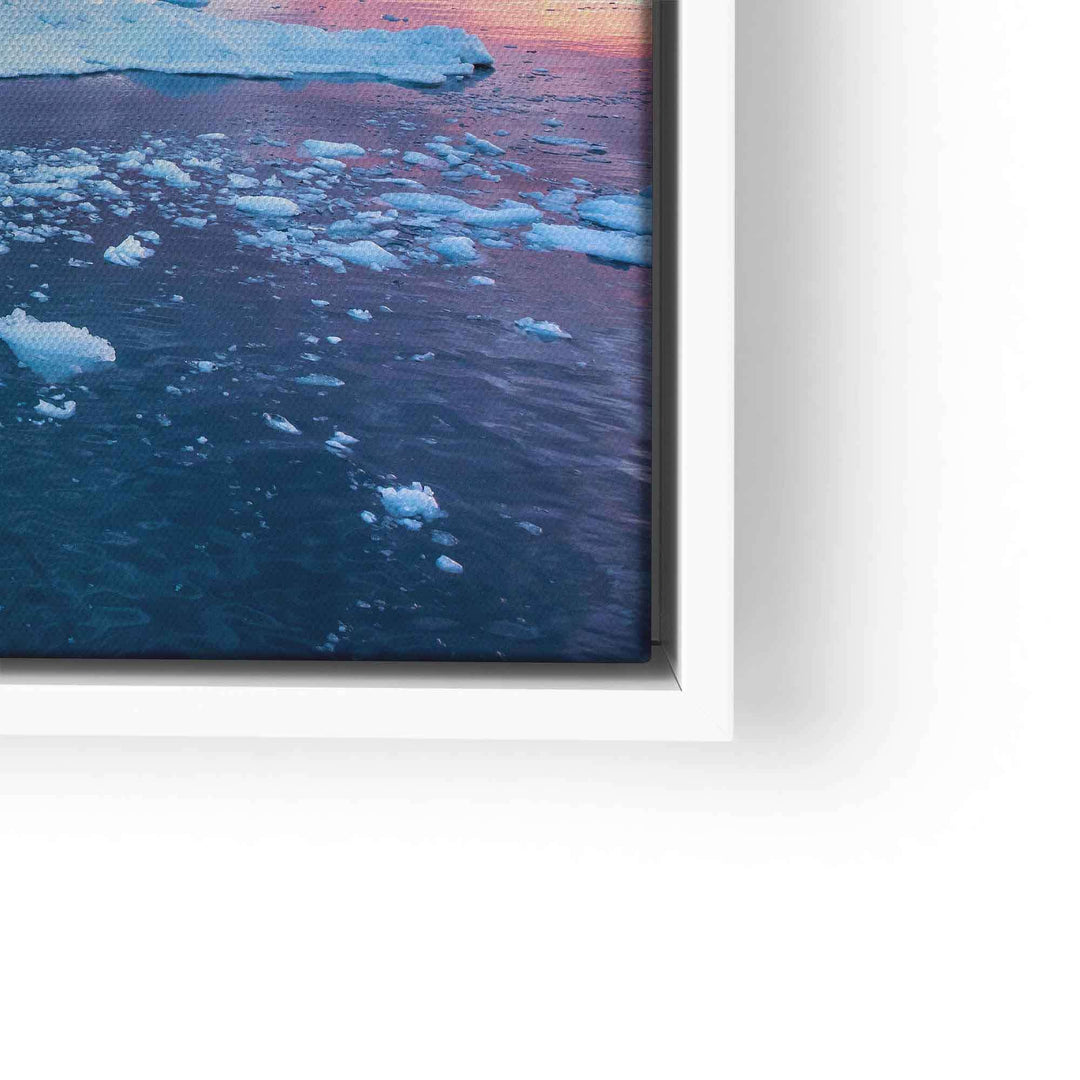 Wandbild mit blauem Eisberg und schwimmenden Eisschollen auf Wasser bei Sonnenuntergang