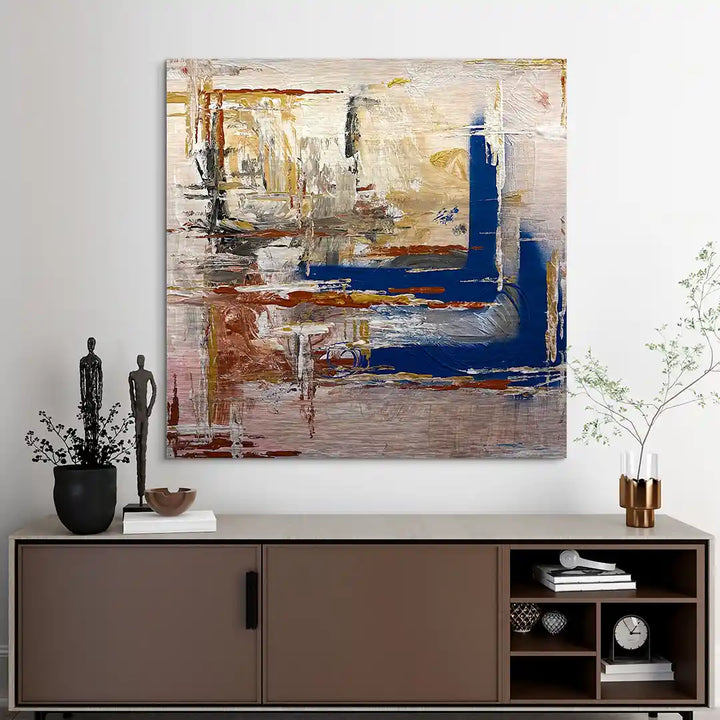 Abstraktes Wandbild mit blauen, braunen und beigen Akzenten über Sideboard im modernen Wohnzimmer.