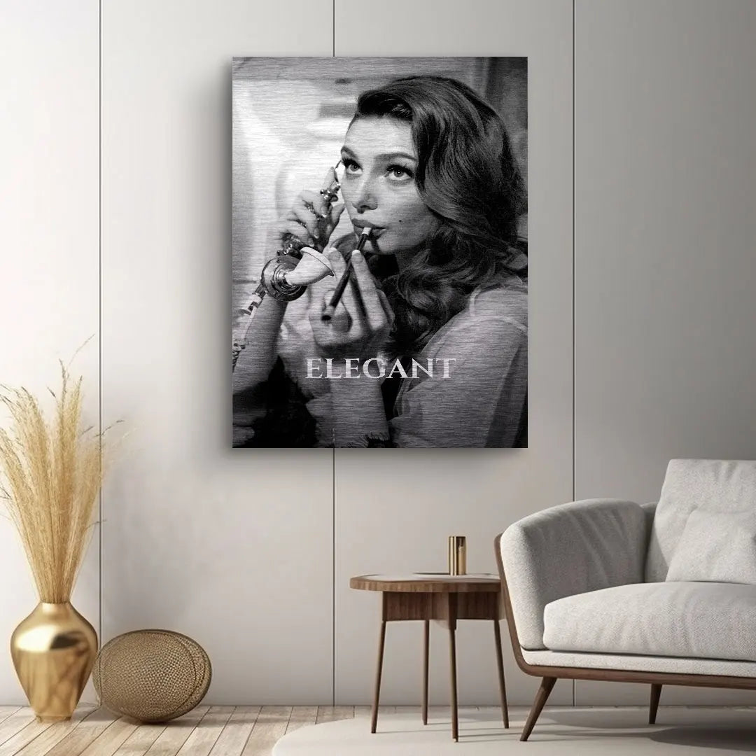 Modernes Wohnzimmer mit schwarz-weiß Wandbild einer Frau beim Schminken und dem Text 'Elegant'.