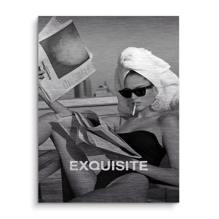 Schwarzweißes Wandbild mit Frau im Badeanzug, Sonnenbrille und Handtuch, liest Zeitung, Schriftzug EXQUISITE