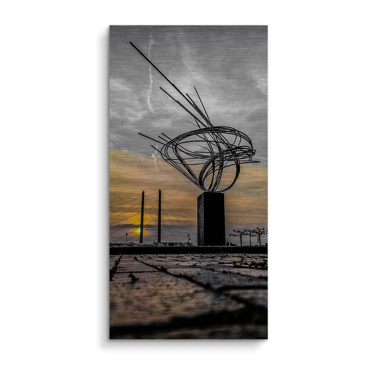 Modernes Wandbild mit abstrakter Skulptur vor Brücke und Sonnenuntergang, künstlerische Fotografie