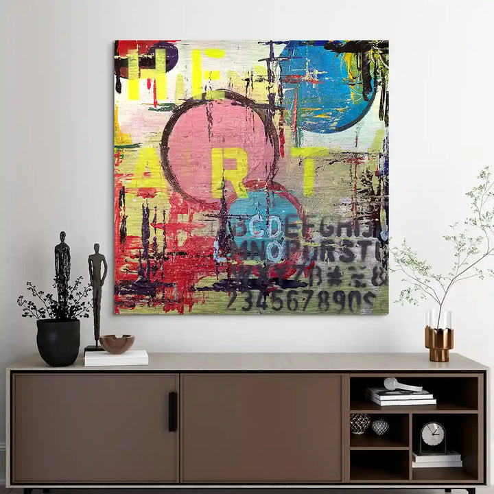 Modernes, abstraktes Wandbild mit Herzmotiv, bunten Farben und Schriftzügen im Wohnzimmer