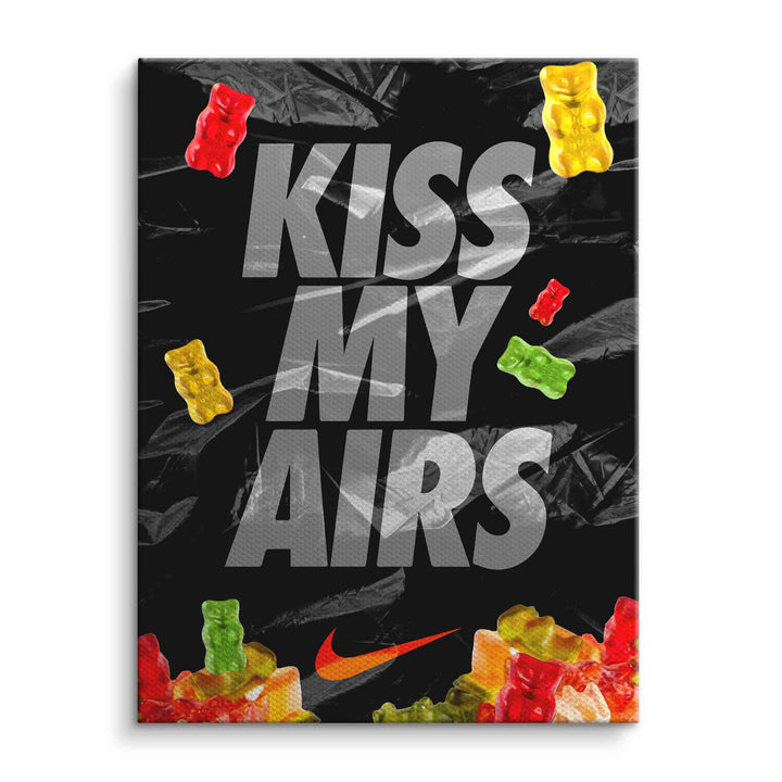 Modernes Wandbild mit „Kiss My Airs“-Schrift, bunten Gummibärchen und schwarzem Hintergrund.