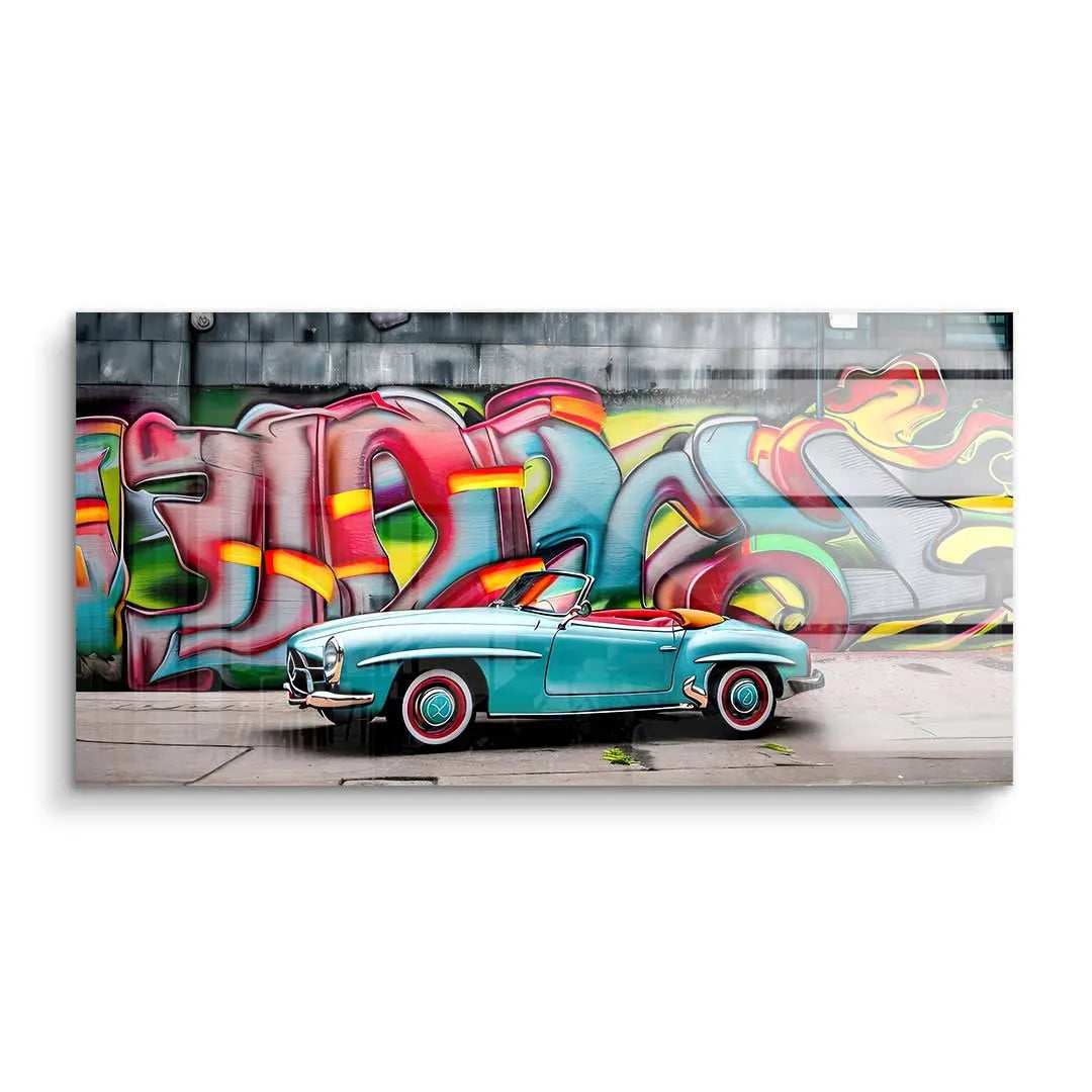 Wandbild mit türkisfarbenem Oldtimer Cabrio vor bunter Graffiti-Wand als moderne Kunst