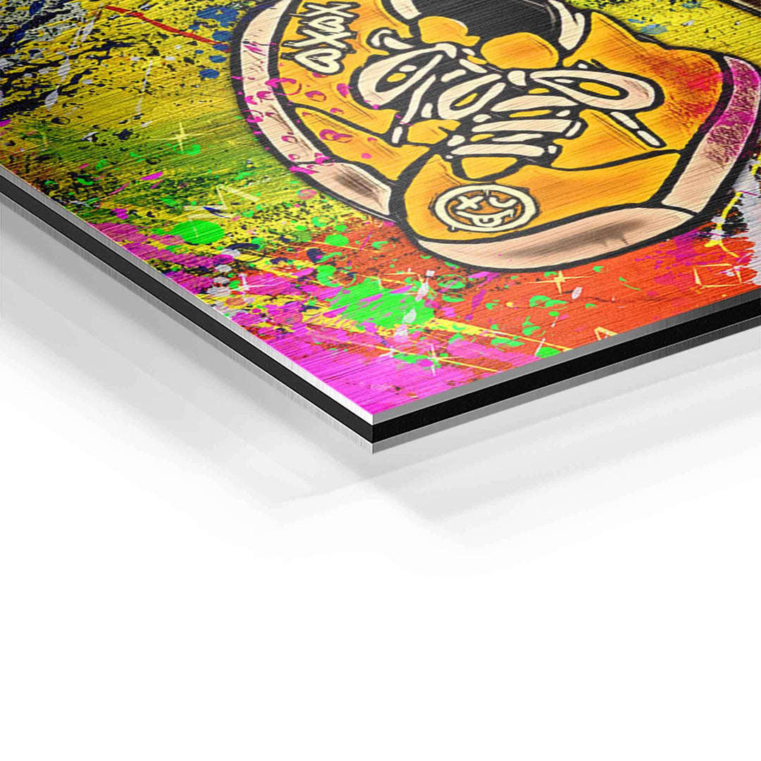 Detail eines Wandbilds mit gelbem Sneaker auf buntem, abstraktem Hintergrund im Pop Art Stil