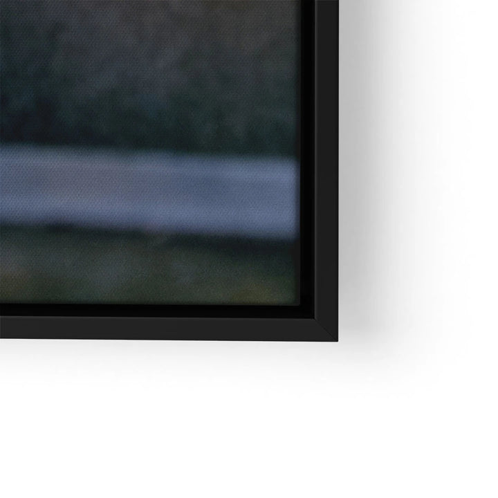 Detail eines Wandbilds mit schwarzem Rahmen auf weißer Wand, Nahaufnahme der Ecke